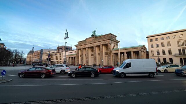 Hyperlapse of Brandenburg Gate in Berlin with daytime traffic, white clouds, and people moving in motion blur