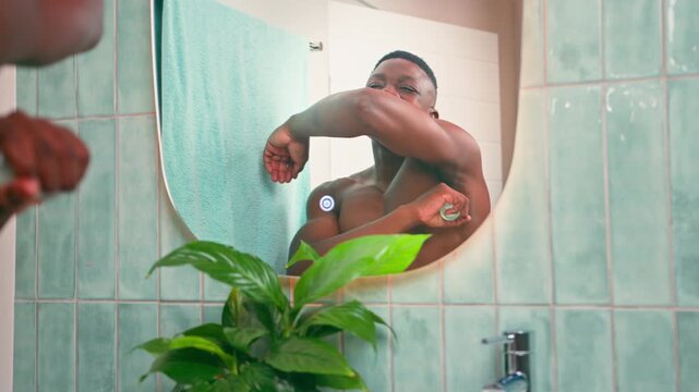 Young Black Man Applies Deodorant in Bathroom Mirror During Morning Hygiene Routine