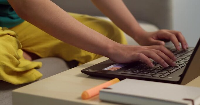 An individual focuses typing a laptop in a comfortable home office setting.