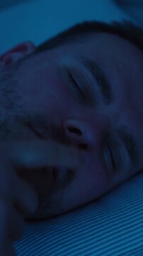 A man sleeps in bed at night with nasal breathing problems, showing blocked nose, snoring, sleep issues, congestion, and health discomfort.