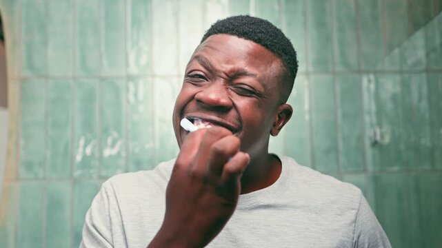 Young Black Man Brushing His Teeth Vigorously for Optimal Oral Hygiene and Freshness