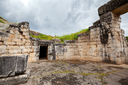 Ancient stone entrance of the Treasury of Minyas, a Mycenaean tholos tomb in Orchomenus, Boeotia, Greece, with weathered masonry, ruins.