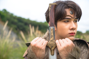 Obraz premium Portrait young male ancient warrior holding sword 
