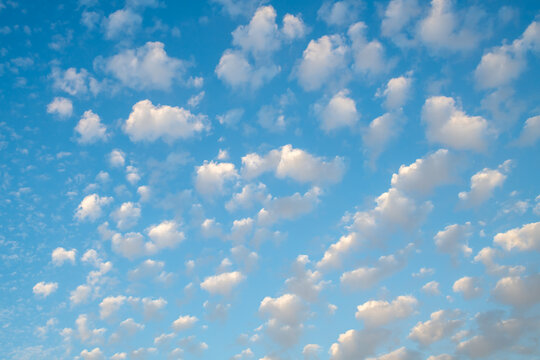 Small puffy white clouds against a bright blue sky. 
