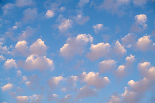 Small puffy white clouds against a bright blue sky. 

