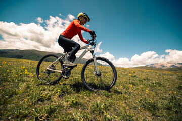 Naklejka premium Mountain biking on flowering grassland mountains