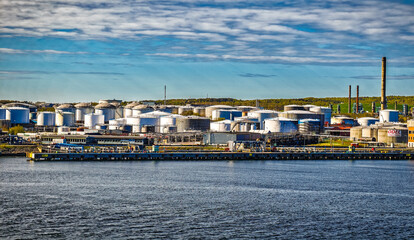 Naklejka premium Oil Refinery Storage Tanks and Industrial Waterfront Terminal Along Harbor With Shipping Infrastructure, Gothenburg, Sweden