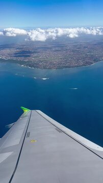 Airplane Wing Banking Left After Takeoff from Bali Airport with Stunning Coastal Aerial View