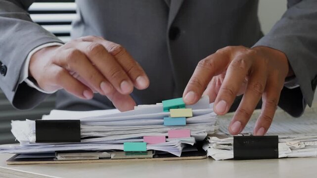 Business professional organizing document files with binder clips on office desk, representing paperwork management, corporate administration, file control, audit workflow, and productivity.