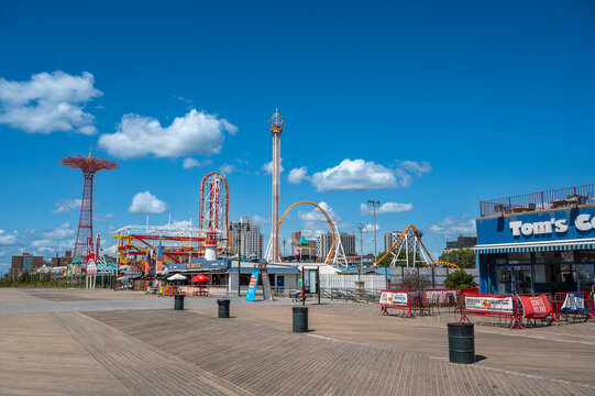 New york, usa august 21,2024. Enjoying a sunny day on the iconic coney island boardwalk, featuring famous amusement park rides like the parachute jump
