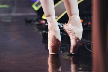 Ballet dancers couple during performance repetition, classic ballet rehearsal practicing in ballroom, view of legs in pointe shoes, ballerina and ballet dancer on a concert hall theatre stage floor © tsuguliev