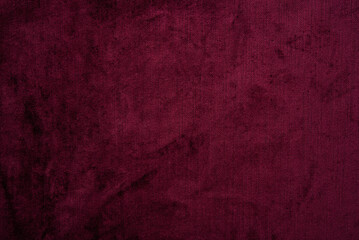 Obraz premium Dark red purple crushed velvet texture background, luxury burgundy velour fabric with soft shiny pattern.