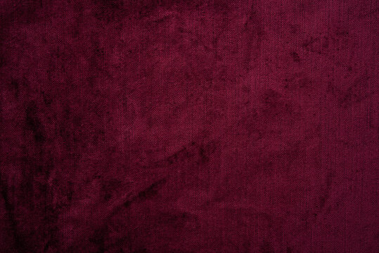 Dark red purple crushed velvet texture background, luxury burgundy velour fabric with soft shiny pattern.