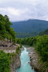 Fototapeta premium Riverside road and misty Soca river in Slovenia surrounded by forest and mountains