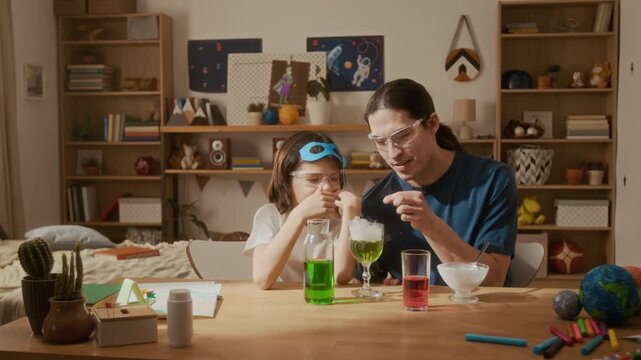 Asian man and multiethnic child conducting chemistry experiment with dry ice at home. Footage is ideal for STEM education marketing and e-learning platform advertisements
