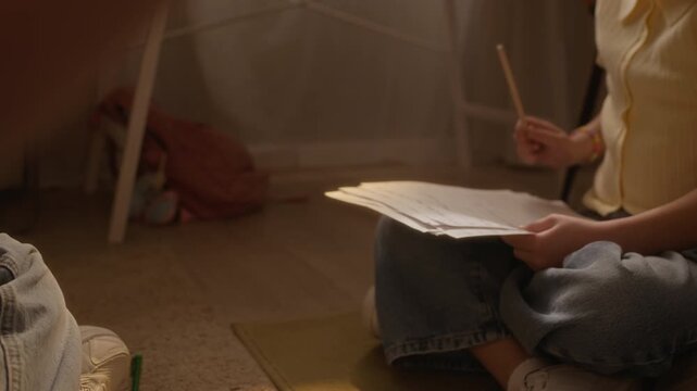 Handheld shot of kid playing flute during home music lesson while Caucasian child student follows notes in background. Ideal for promoting private tutoring and creative education services