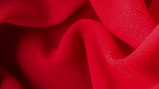 Soft red satin fabric texture background, elegant textile folds, luxury material surface, fashion and design concept.