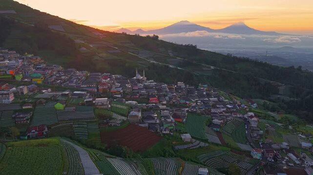 Early morning drone shot of mountain village, sunrise light over terraced fields and colorful homes. Nepal Van Java, Indonesia.