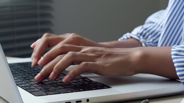Hands Typing on Computer in Modern Office