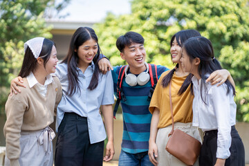 Fototapeta premium Joyful group of friends sharing laughter outdoors campus setting candid photo bright day close-up friendship concept