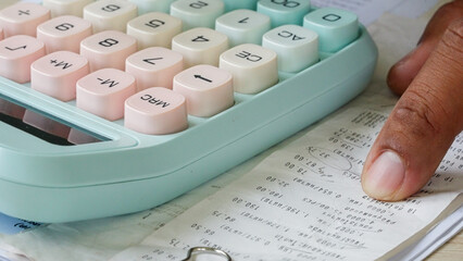 Hand presses calculator keys with focused intent. Paper holds handwritten notes beside the device. Soft pastel colors suggest calm, precise calculations. Finger rests near numbers