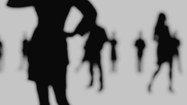 Blurred silhouettes of business people walking forward. Anonymous business figures on the move, out of focus. Blurred silhouettes of office workers.