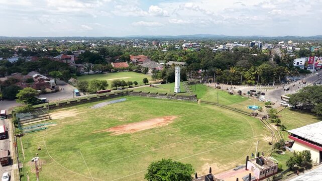 Aerial view of Matara Fort and the historic clock tower overlooking a large green cricket field and the surrounding urban landscape in Matara, Southern Province, Sri Lanka.