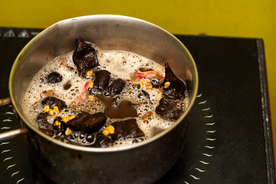 Homemade Herbal Shampoo Ingredients Boiling in Pan on Induction Cooktop