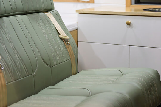 Close up of green leather seats and cabinets inside RV