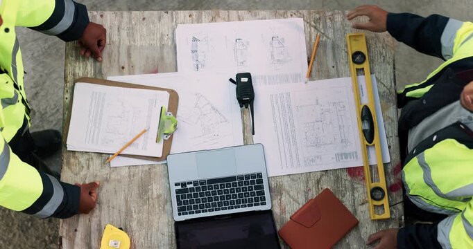 Blueprint, laptop and construction managers with handshake on site for industrial partnership. Floor plan, men and civil engineers shaking hands for agreement on building with computer from above.