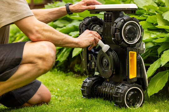 Robotic lawn mower maintenance. Cleaning blades with brush