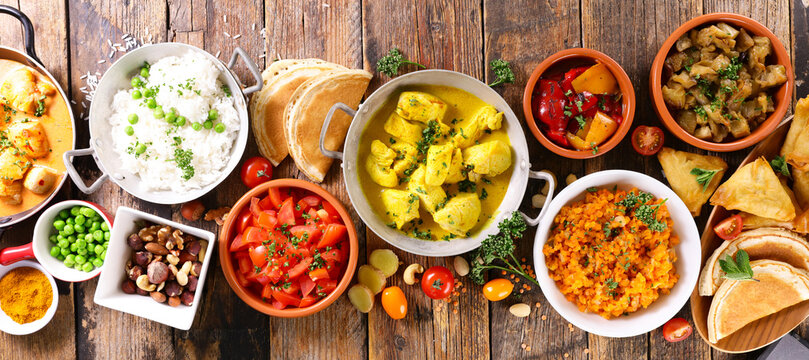 flat lay indian food banner with chicken curry, samosas, and rice on rustic wooden table
