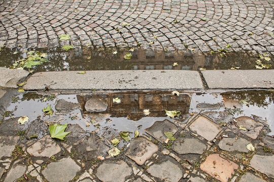 An urban image in Paris, with a reflection in a puddle