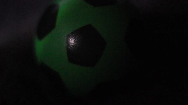  Una toma de cerca de una pelota o bal&oacute;n de f&uacute;tbol  con varias luces en un fondo negro 