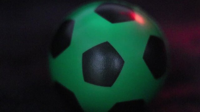  Una toma de cerca de una pelota o bal&oacute;n de f&uacute;tbol  con varias luces en un fondo negro 
