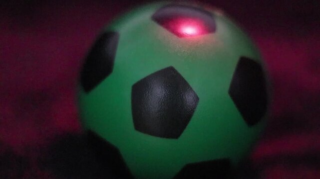 Una toma de cerca de una pelota o bal&oacute;n de f&uacute;tbol  con varias luces en un fondo negro 