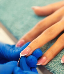 Fototapeta premium Manicure treatment in the nail salon, putting artificial nails