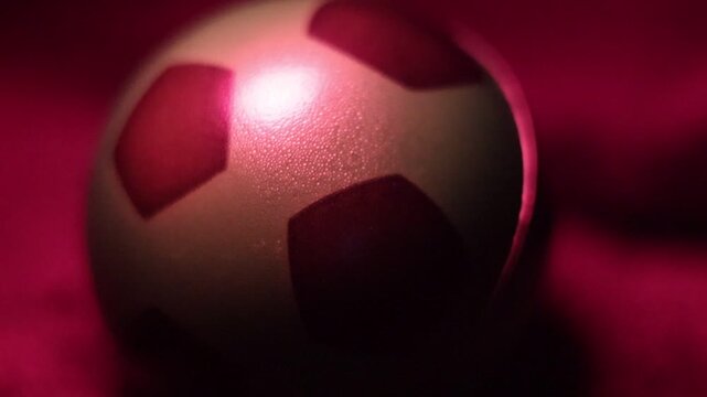  Una toma de cerca de una pelota o bal&oacute;n de f&uacute;tbol  con varias luces en un fondo negro 