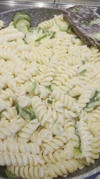 preparazopme di una ricetta con pasta fusilli in una padella sul fuoco