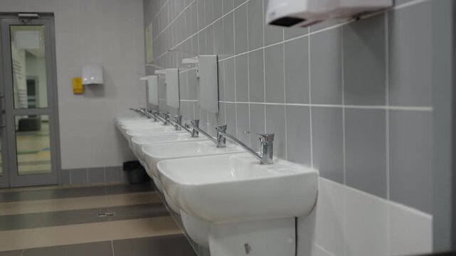 Clean school handwashing station features comtemporary minimalist design. Uniform layout creates organized and sterile atmosphere