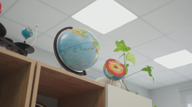 Educational models for science lessons stand on cabinet tops in empty classroom. Well-lit interior establishes welcoming study atmosphere