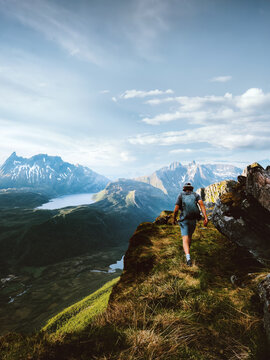 Man hiking solo in mountains active summer travel vacations in Norway, tourist with backpack explore wild trails in Lofoten islands traveler trekking outdoors adventure lifestyle freedom endurance