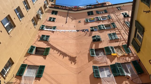 Washing clothes and hanging them to dry in an old building in Genova Italy during a sunny day