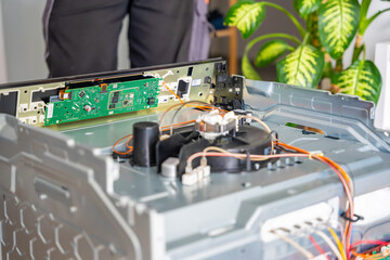 Naklejka premium Electronic control panel removed from electric oven during repair. Appliance diagnostics and maintenance concept