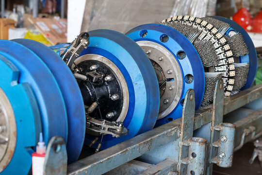 Industrial smart pigging tool equipped with blue polyurethane cups and heavy duty wire brushes for pipeline cleaning and inspection.