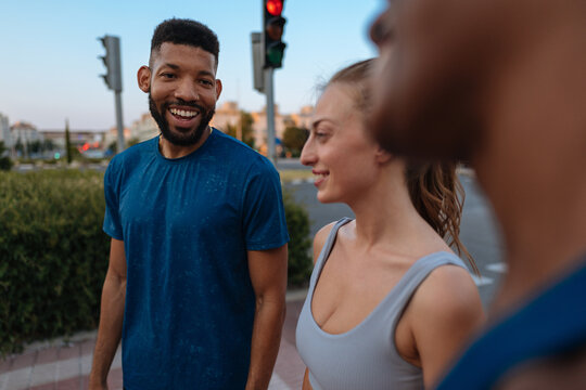 Friends jogging together on city street