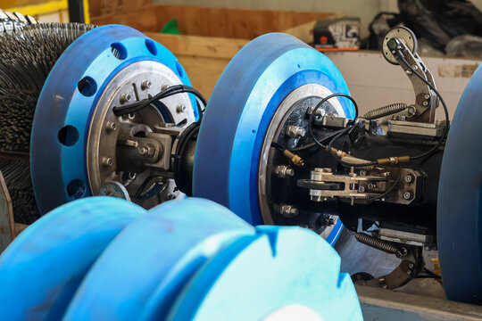 Industrial smart pigging tool with blue polyurethane cups and sensors for pipeline inspection and cleaning in a workshop.