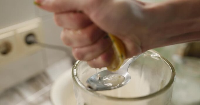 Male hand squeeze lemon juice in blender. Man prepare food cook at kitchen at home. 4K 10-bit