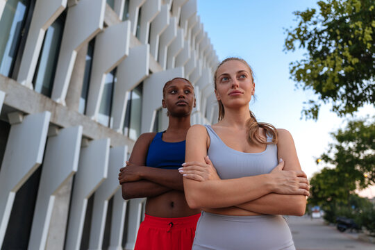 Diverse women standing strong with arms crossed outdoors