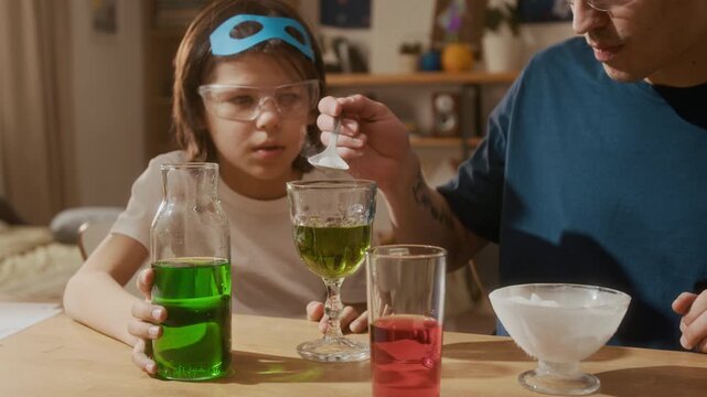 Multiethnic child and young Asian man conducting chemistry experiment with dry ice at home. Footage ideal for promoting STEM education, science kits, and interactive learning